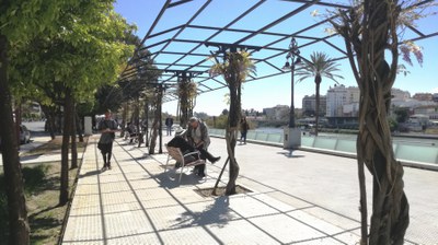 Ciudadanos paseando o descansando en los nuevos bancos del remodelado aderado del Paseo Colón
