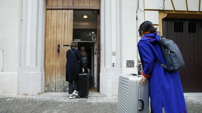 Dos turistas acceden con su equipaje a una vivienda turística de Sevilla