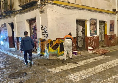 Una persona limpia unas pintadas de las fachadas de una vivienda en el Casco Antiguo de Sevilla