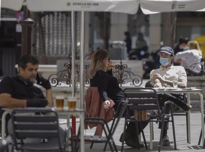 Ciudadanos sentados en unos veladores en una calle de Sevilla