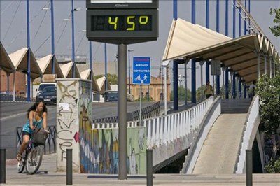 Una joven pasa por delante del puente del Cristo de la Expiración de Sevilla, a 45 grados de temperatura