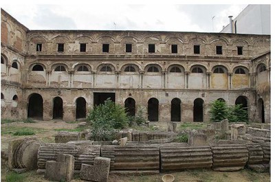 Fachada este del claustro del antiguo convento y primer plano de los restos de la portada de acceso al compás de la exiglesia, que permanecen sobre el suelo del claustro