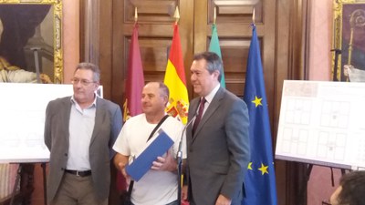 El alcalde de Sevilla y el Gerente de Urbanismo hacen entrega del proyecto para la instalación de un ascensor al representante de una de las comunidades de vecinos beneficiarias
