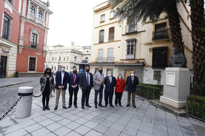 El alcalde de Sevilla posa junto al monumento acompañado por el delegado del Casco Antiguo, representantes de la asociación club del libro Puerta Carmona y del hijo del escultor Sebastián Santos