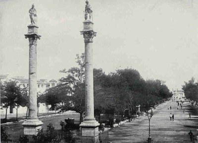 Vista general de la Alameda en el siglo XIX, con las columnas de Hércules y Julio César en primer término, rodeadas de sus primitivas rejas perimetrales 