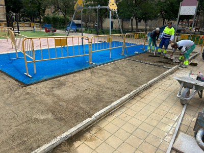 Operarios de la la empresa de conservación del viario contratada por Urbanismo colocan el nuevo pavimento junto a la zona de juegos infantiles de la calle Puerto de Envalira