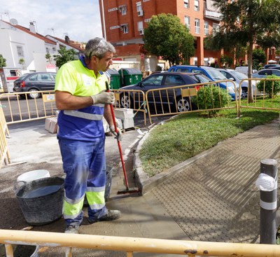 Un operario culmina los trabajos de realización de un rebaje en un acerado de una calle de Sevilla