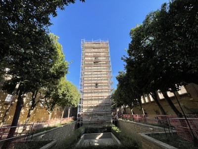 La Torre de don Fadrique, cubierta de andamios, vista desde los jardines que la rodean