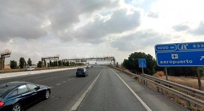 Vehículos circulando por la SE-20 junto a una indicación de desvío hacia el aeropuerto de Sevilla