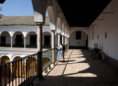 Una monja contempla el atrio de un convento de Sevilla desde uno de los corredores del piso alto 