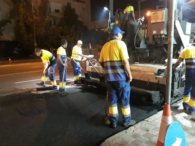 Operarios realizando trabajos de reasfaltado de la calzada de una calle de Sevilla