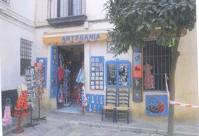 Ejemplo de establecimiento en el barrio de Santa Cruz con numerosos expositores en la fachada y la vía pública
