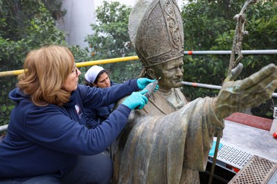 Operarias de la empresa de conservación retiran la suciedad incrustada en el rostro de la imagen del difunto apa 