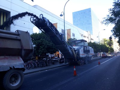 Trabajos de reasfaltado en la calle Luis de Morales, a la caída de la tarde