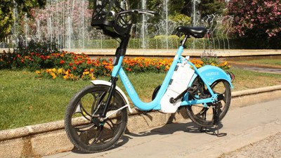 Imagen de una bicicleta eléctrica aparcada a la entrada de una zona verde